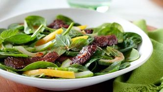 Shaking beef salad with baby spinach and mango