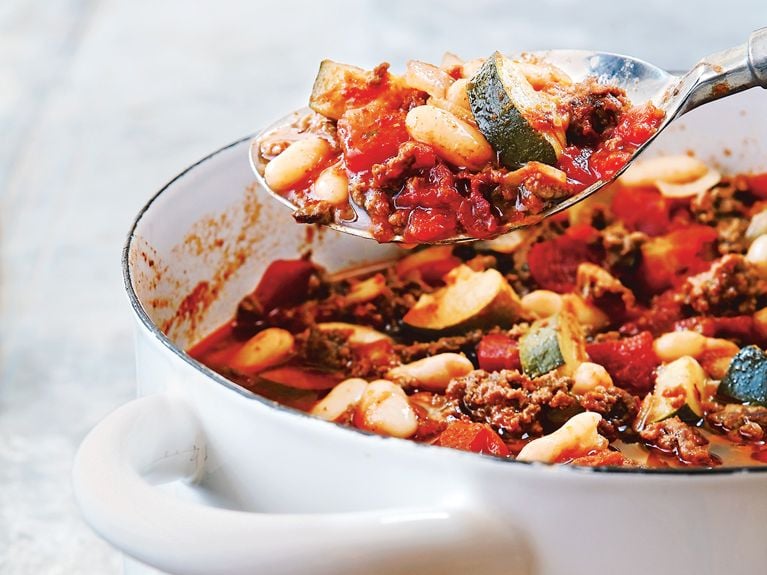 A white enamel pot filled with vegetable bean and beef chili.
