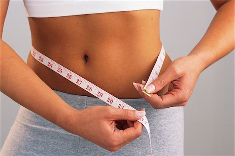 Woman measuring her waist