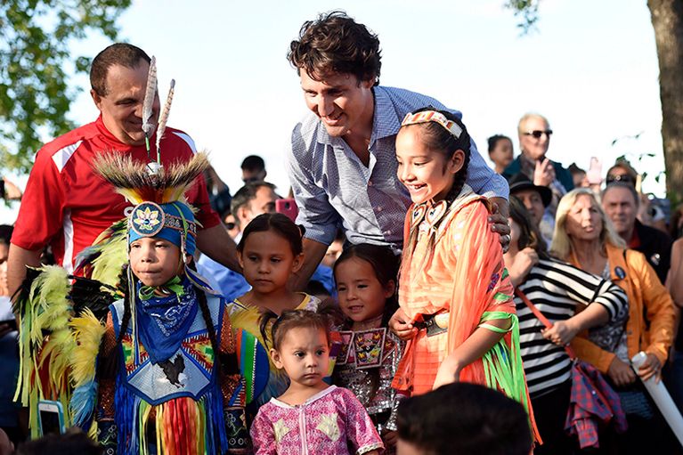 Prime Minister Justin Trudeau, back centre, poses for a photo with aboriginal youth dancers at a barbecue at the Liberal cabinet retreat in Sudbury, Ont., on Monday, August 22, 2016. THE CANADIAN PRESS/Nathan Denette