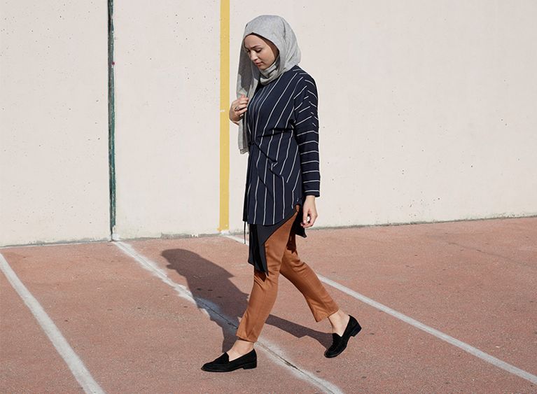 A CAMPAIGN SHOT FROM THE COLLECTION, FEATURING A SCARF, HIGH-NECK TUNIC, AND TAPERED PANTS. (PHOTO: COURTESY UNIQLO)
