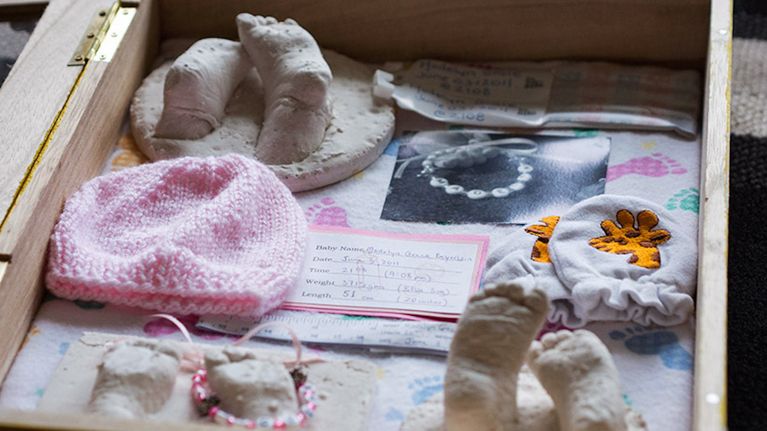Madelyn's memory box opened, containing molds of her feet, the hat, mittens and receiving blanket she wore after her birth, a photo from the hospital and other small mementos. Photo, Seema Marwaha.