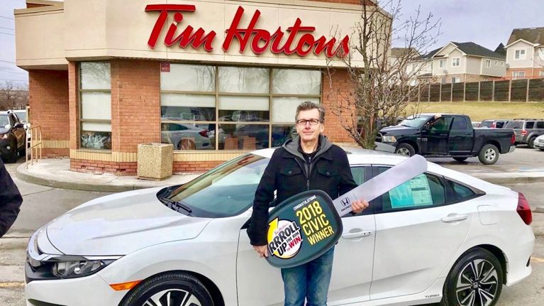 Roll-Up-The-Rim New-Car Prize winner Brian Banks poses with the Honda Civic car