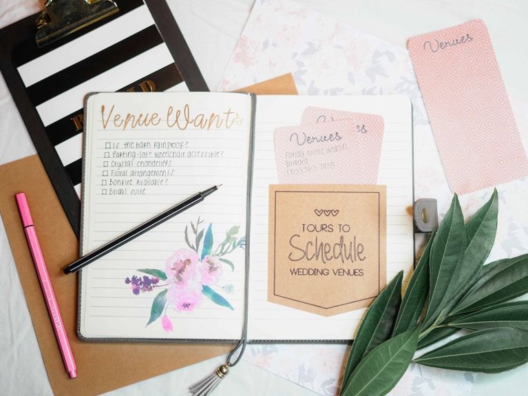 Wedding planner flat lay of notebok and divider cards.