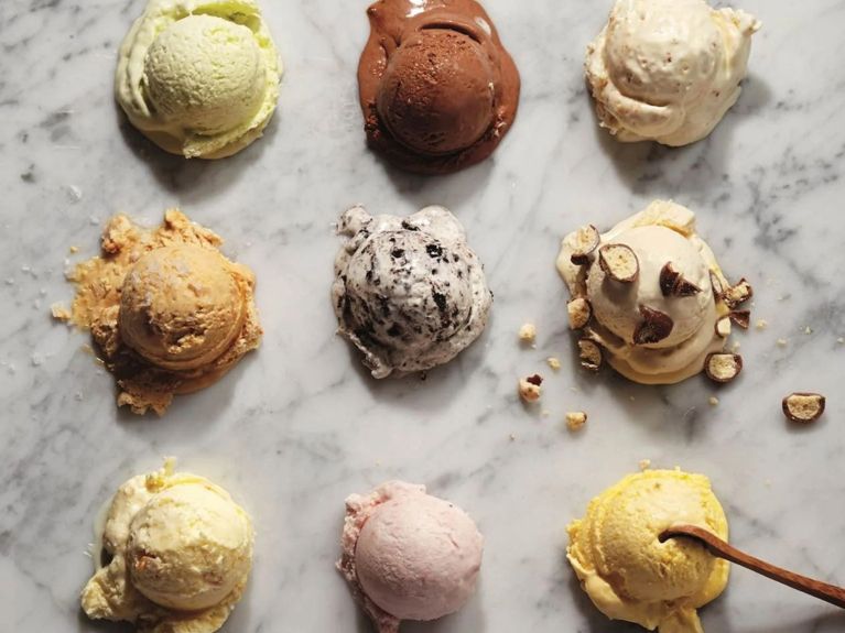 The difference between ice cream and gelato, explained. Image of nine ice cream scoops on marble table