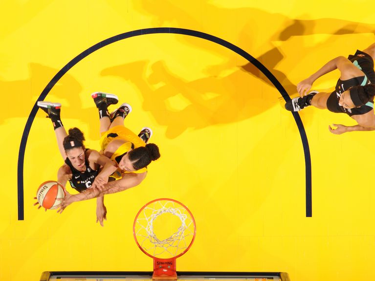 Kia Nurse plays on a yellow court