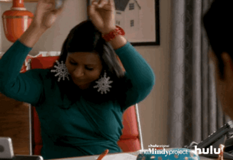 Mindy from best netflix sitcom the mindy project waves her fingers above her head