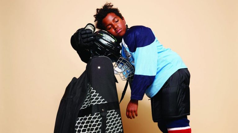 kids rep competitive sports-hockey goalie kid falling asleep on his equipment bag