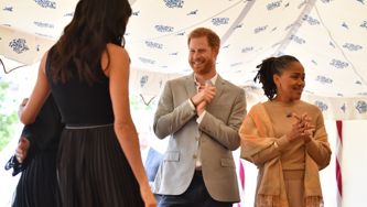 Watch Prince Harry Smooth Out Meghan's Hair (And Steal Samosas)