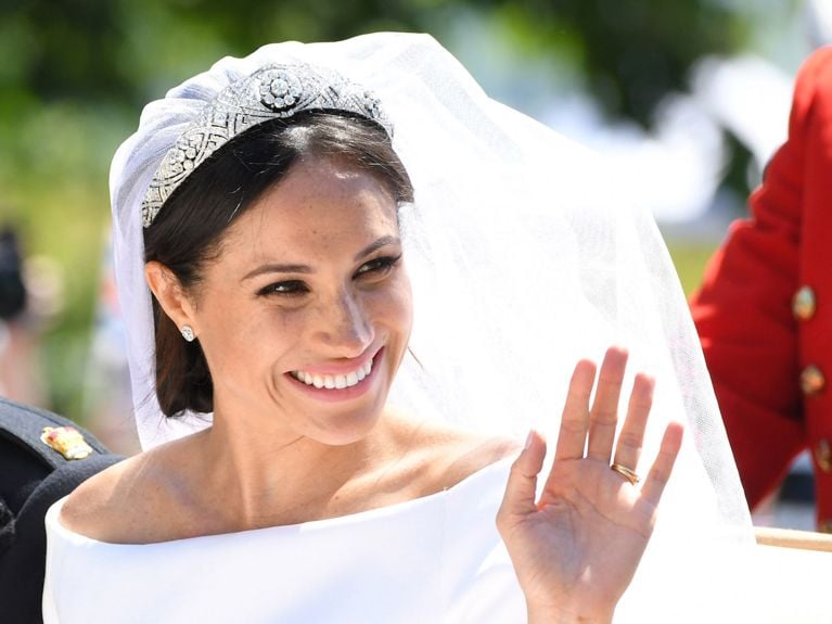 Meghan Markle reunited with wedding dress in HBO documentary- Meghan wears her veil, tiara and gown as she sits in a carriage waving at fans.