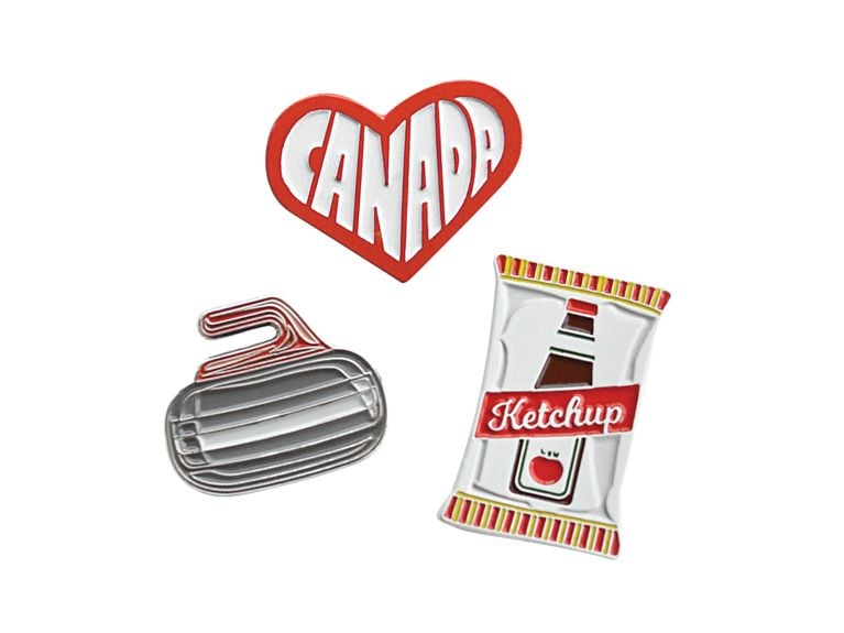 Holiday Gift Guide 2018 small enamel pins featuring Canadian-themed objects: a razor, a bag of ketchup chips, a heart around the word Canada