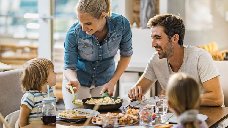 meal kit delivery feature image of a woman serving a meal to her husband and two children