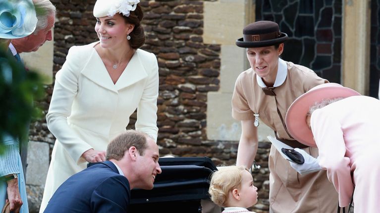 Kate Middleton and Prince William wearing formal clothing as their nanny bends down to talk to Price George