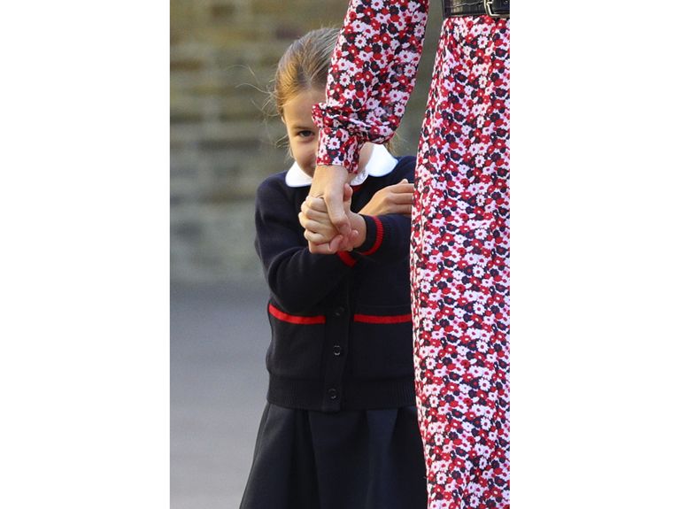 Charlotte hides behind her mother as she holds her hand