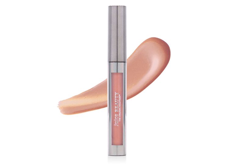 A picture of a shimmery champagne Juice Beauty lip gloss to illustrate a round-up of ethical mica makeup products.