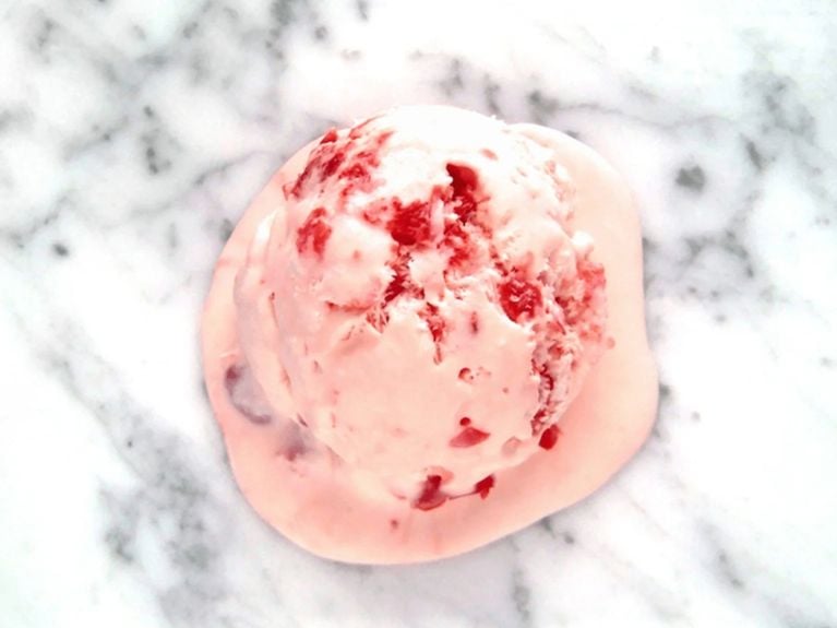 a scoop of cherry chip  ice cream on a marble countertop