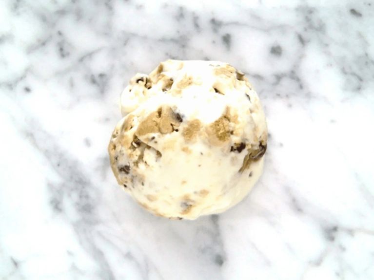 a scoop of cookie dough ice cream on a marble countertop