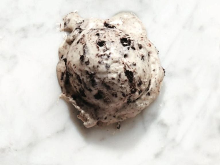 A scoop of cookies and cream ice cream on marble counter top