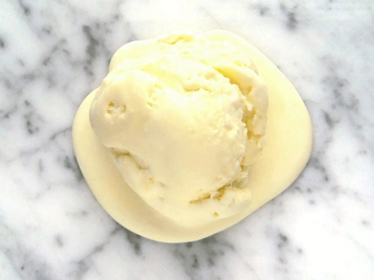 a scoop of orange creamsicle ice cream on a marble countertop