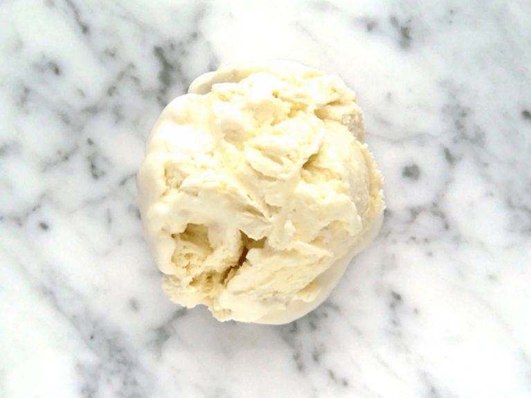 a scoop of maple ice cream on a marble countertop
