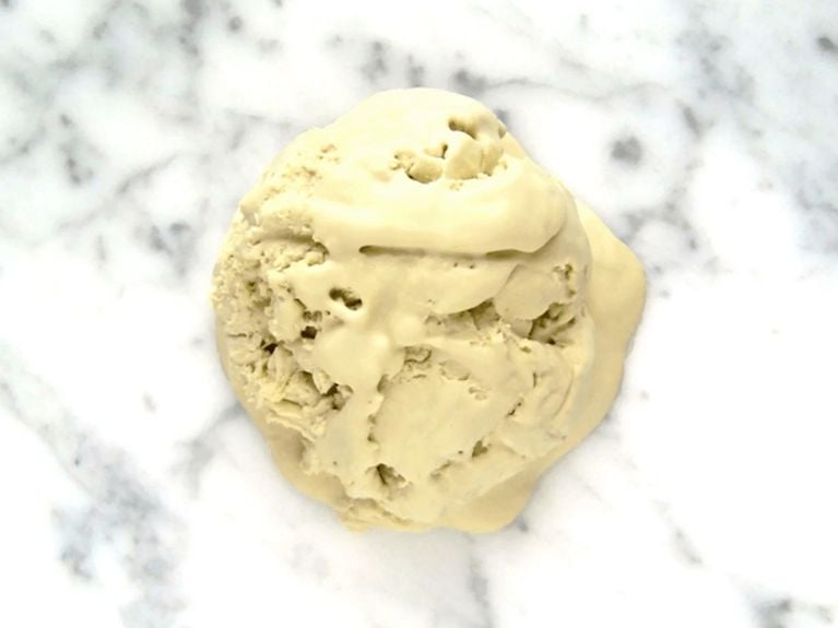 a scoop of matcha ice cream on a marble countertop