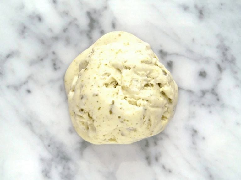 a scoop of pitstachio ice cream on a marble countertop