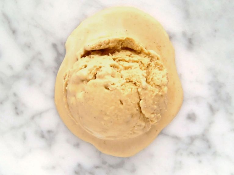 a scoop of pumpkin pie ice cream on a marble countertop