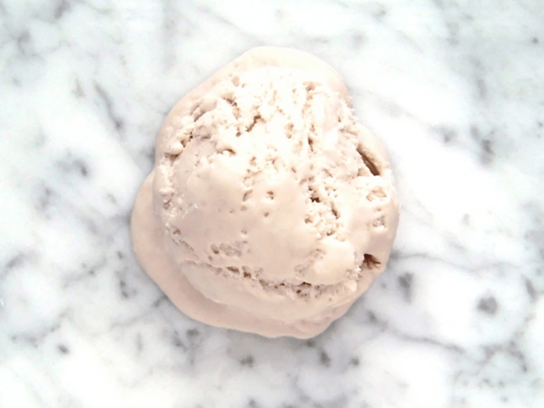 a scoop of raspberry ice cream on a marble countertop