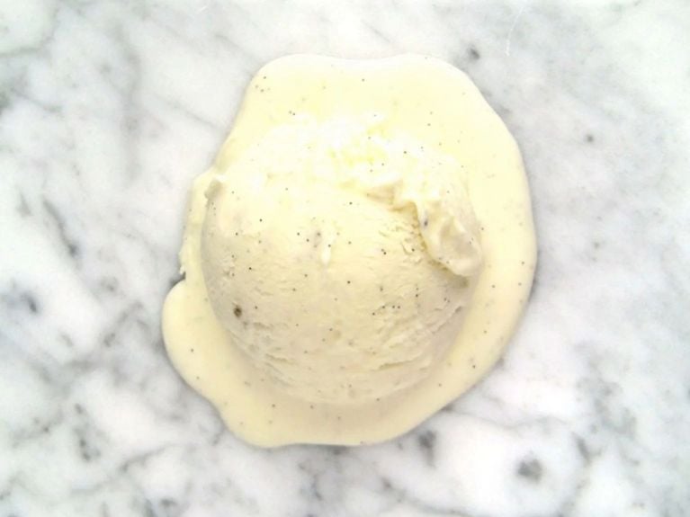 a scoop of vanilla ice cream on a marble countertop