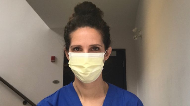 The writer in a hospital setting in a mask