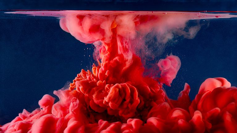 A cloud of red ink dispersed in water.