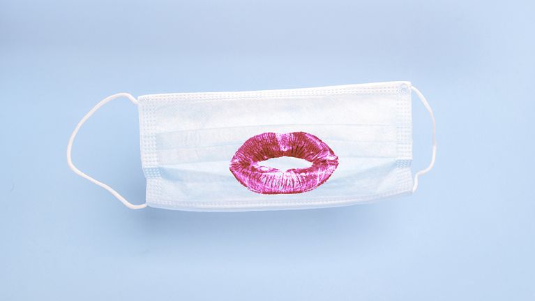 a photo of a face mask with a lipstick kiss on it for a piece on whether hookups are okay right now