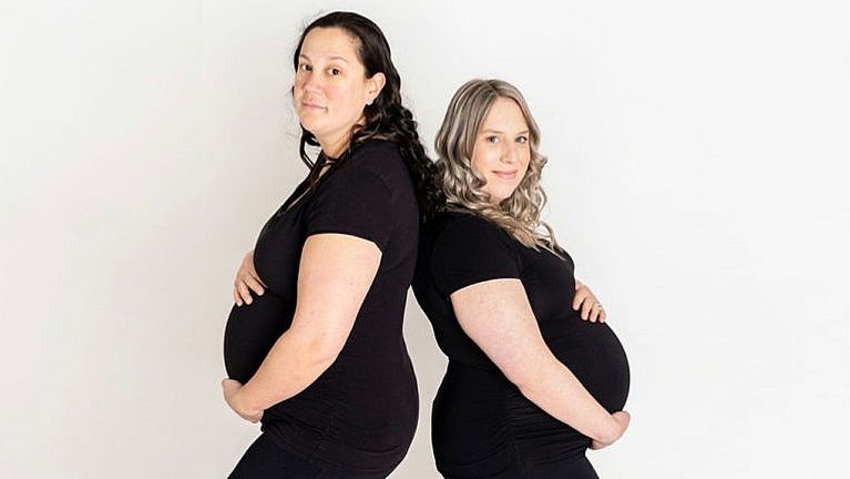 The two moms, pregnant, post back to back