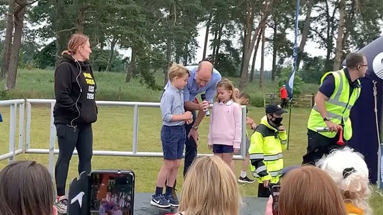  e see the two elder Cambridge kids dressed down in their shorts and Nikes while huddled around their dad’s microphone