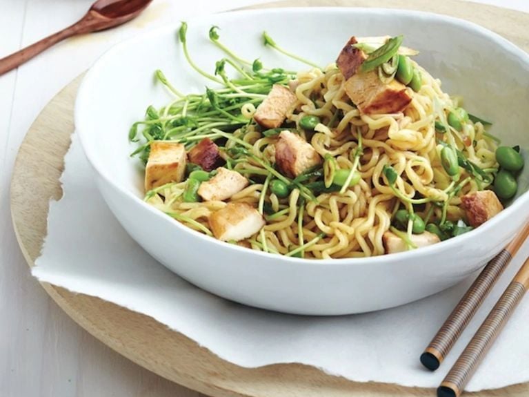 Chicken and pea sprout ramen in a bowl with chopsticks