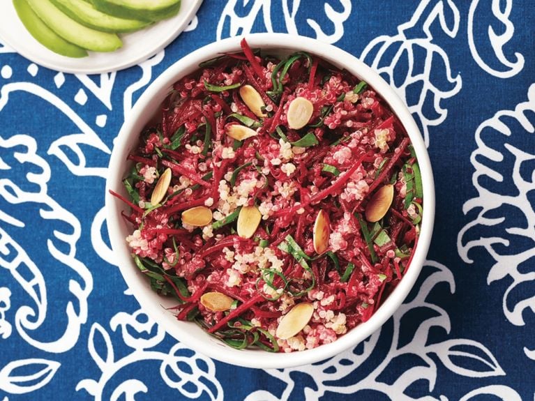 Sesame, ginger and beet grain bowl on a white and blue floral placemat 