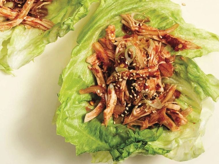 Chicken with red sauce in lettuce cup.