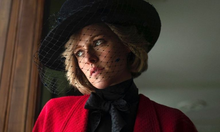 Kristen Stewart dressed as Princess Diana in a black hat and red jacket