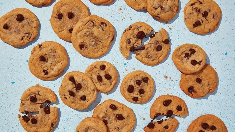 Pieces of chocolate chip cookies with a blue background.