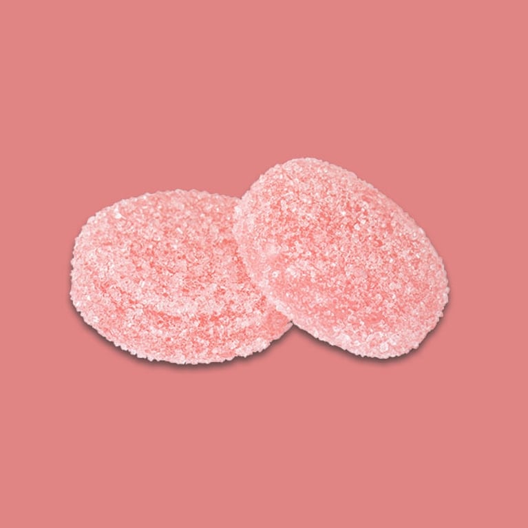 Two white nectarine Fly North Weed gummies that are 1:1 cbd and THC for a piece on beginners' guide to soft chews