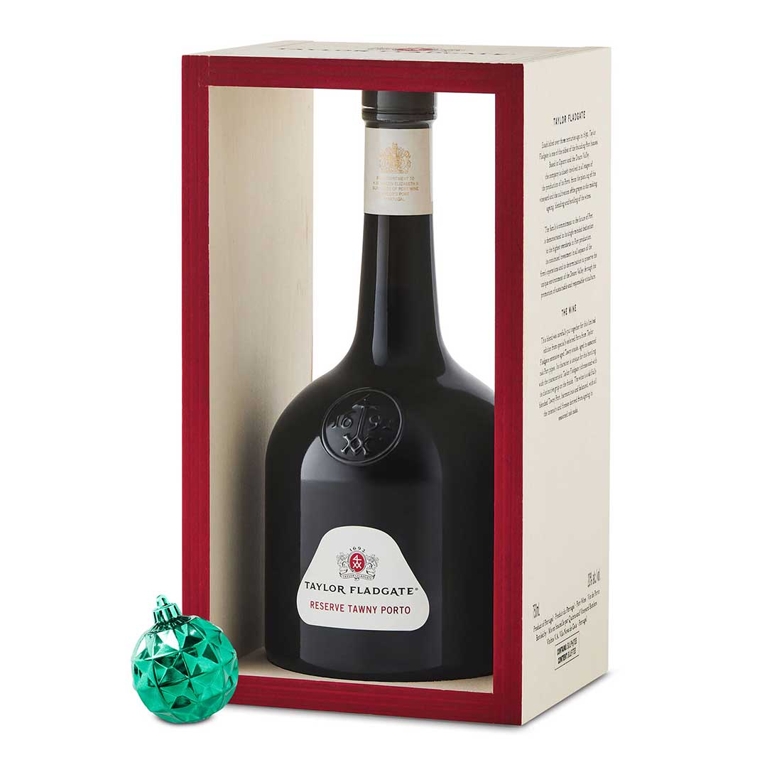 a bottle of Taylor Fladgate Reserve Tawny Historical - The Mallet Port in a gift box next to a green Christmas tree ornament