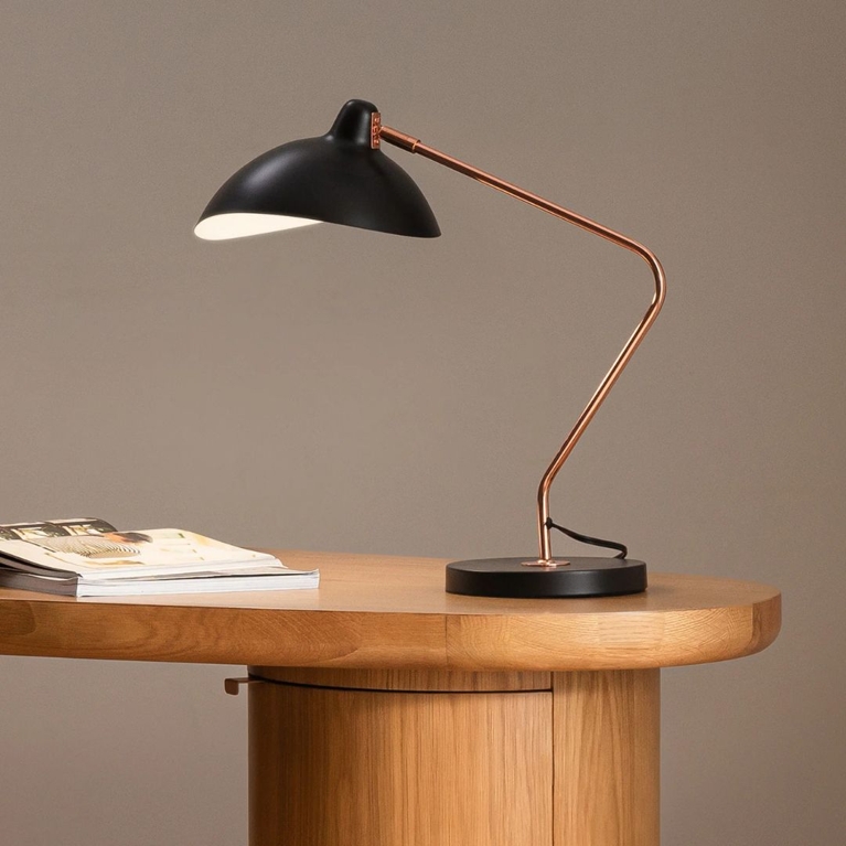 A black metal table lamp on a wooden side table, for a post about the best gifts for book lovers.
