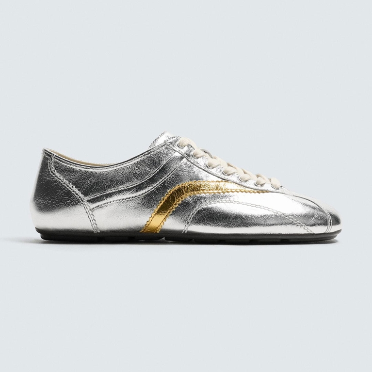 A pair of Zara sneakers with a pop of gold for an article about the silver shoe trend.