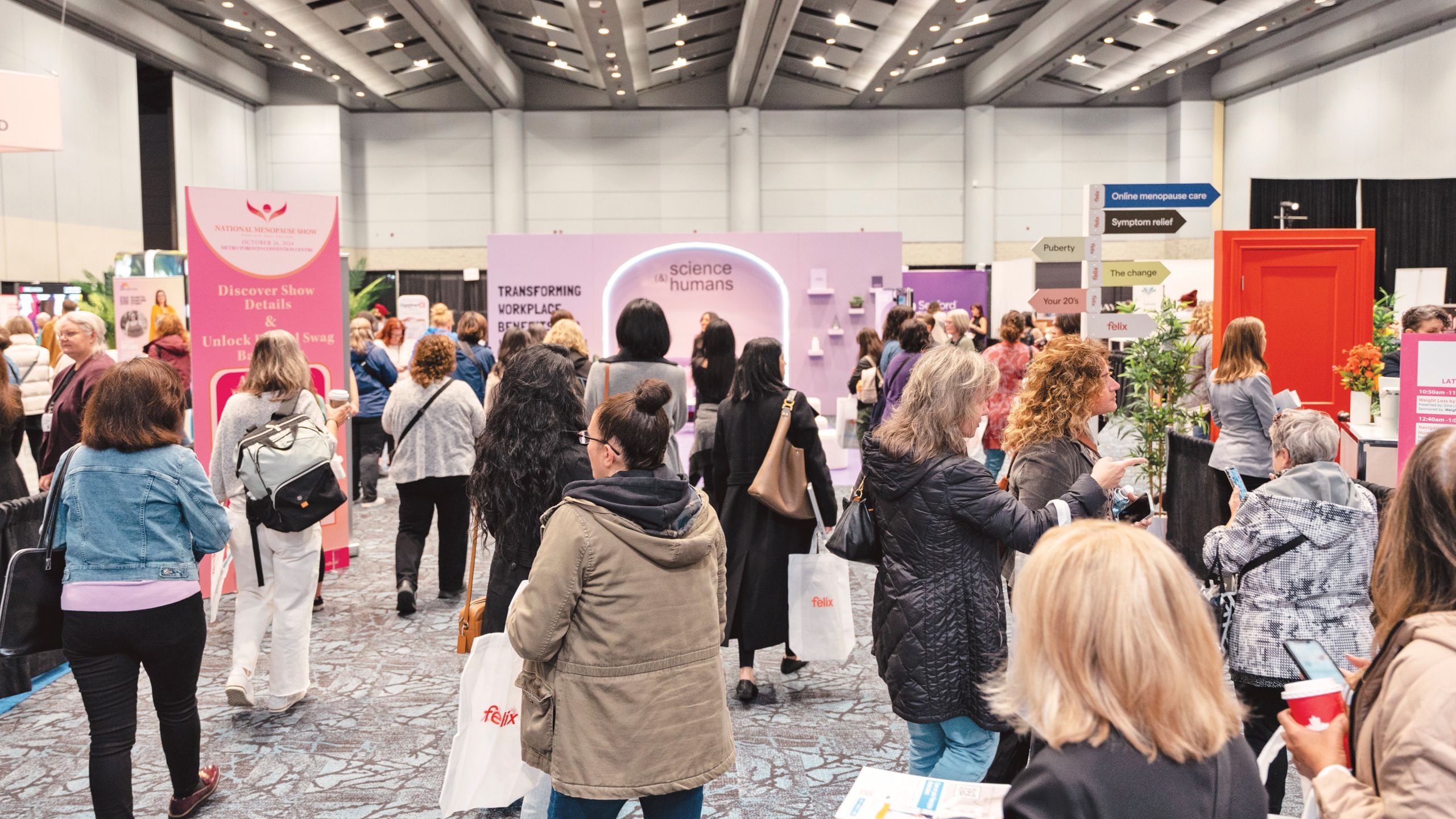 Women walk through a marketplace of menopause-related products at the National Menopause Show in Toronto.