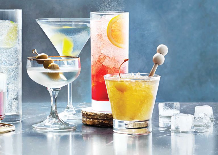 A rum sour in a cocktail glas adorned with a cherry and a wood swizzle stick for a post on an easy rum sour cocktail recipe