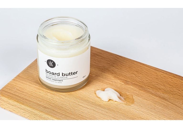 A jar of board butter treatment placed on a wooden board