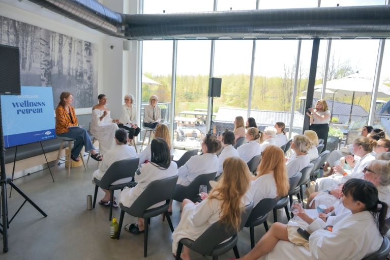 A group of women in robes watching a panel discussion at the Chatelaine Wellness Retreat.