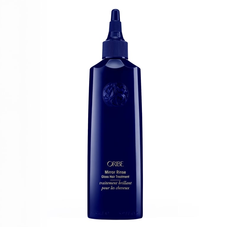 A blue bottle of Oribe Mirror Rinse Glass Hair Treatment on white background for an article about the best hair gloss treatments.