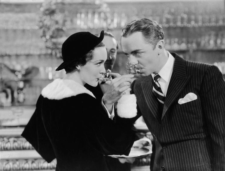 Myrna Loy and William Powell as Nick and Nora Charles holding the glasses that inspired Nick & Nora cocktail glasses in a cut scene from the 1934 movie The Thin Man. (Photo by FilmPublicityArchive/United Archives via Getty Images)