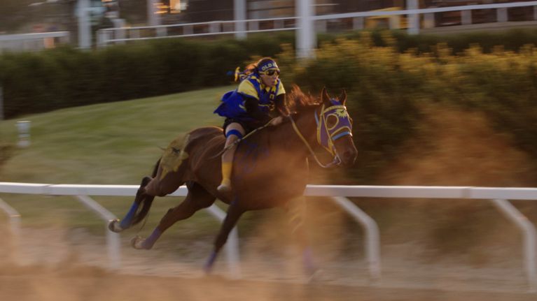 Logan Red Crow crosses the finish line on a relay race track.